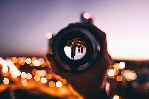 shallow focus photography of person holding camera lens